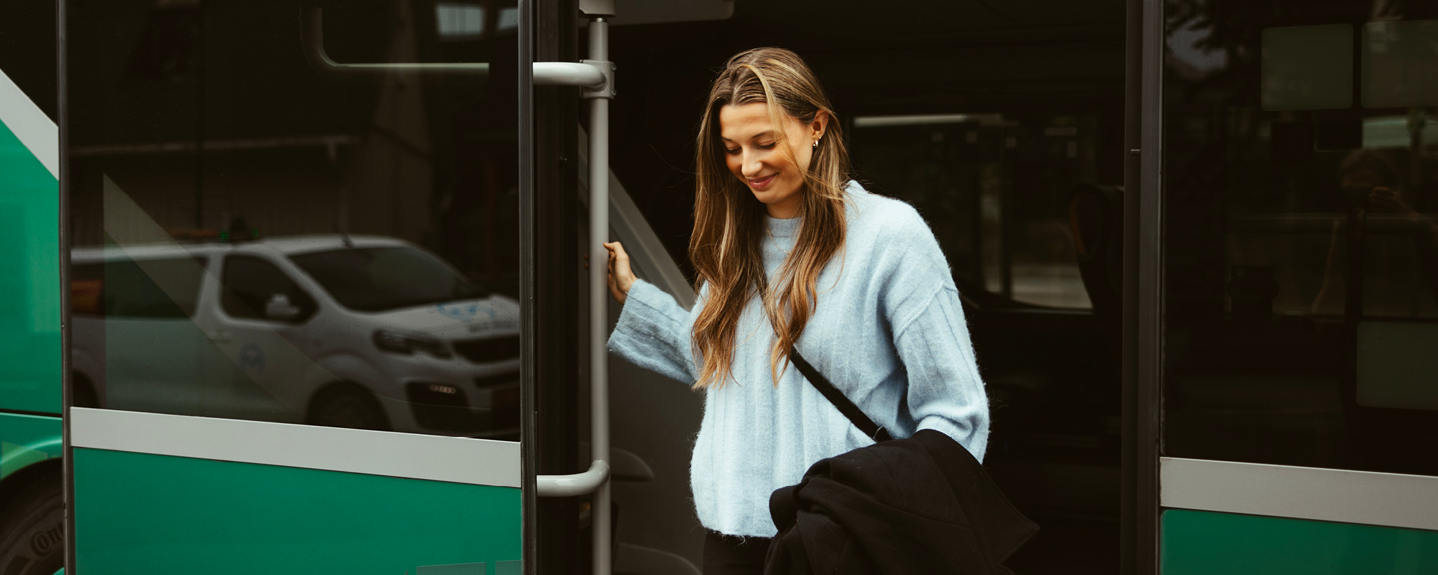 Kvinna går av en buss.