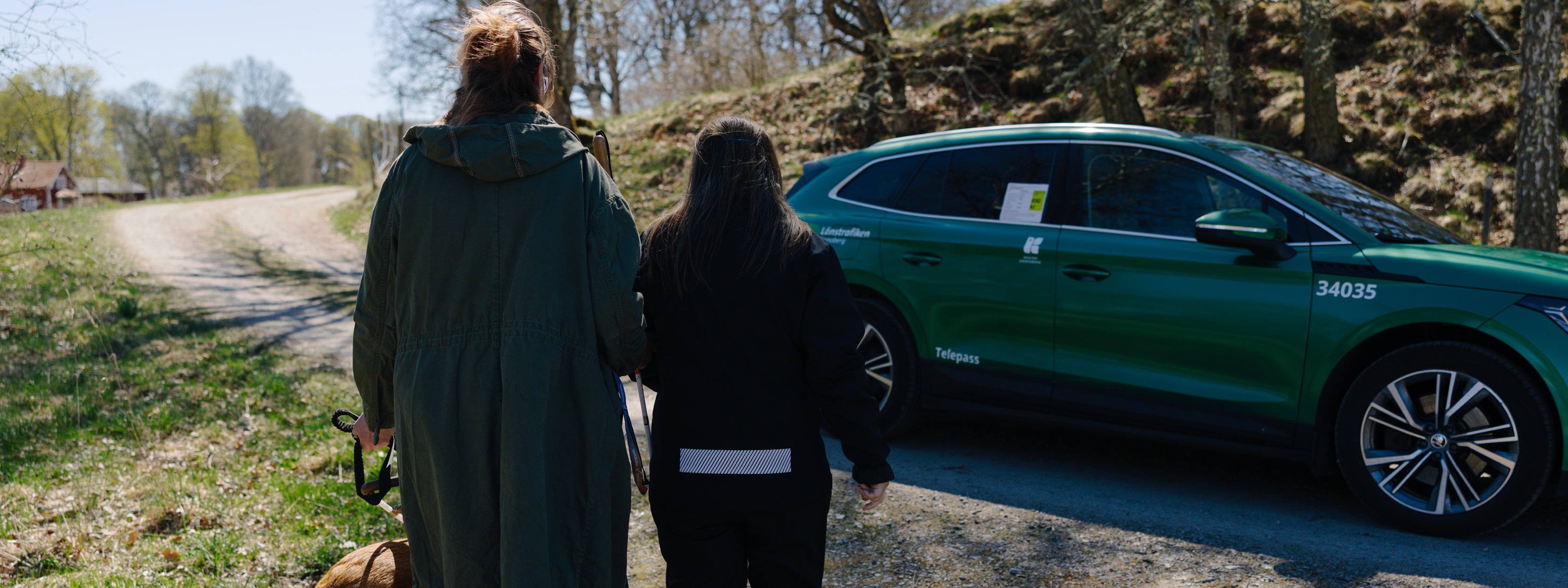 En kvinna får hjälp av en förare som leder henne till bilen, 